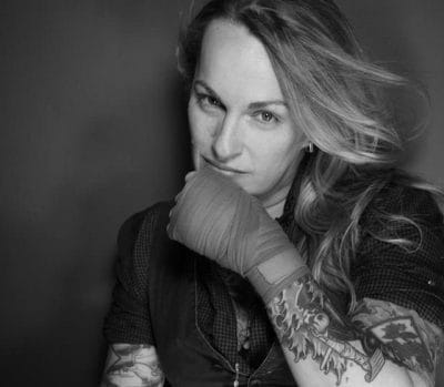 Tattooer Tiger Kate in boxing wraps with her hair down.